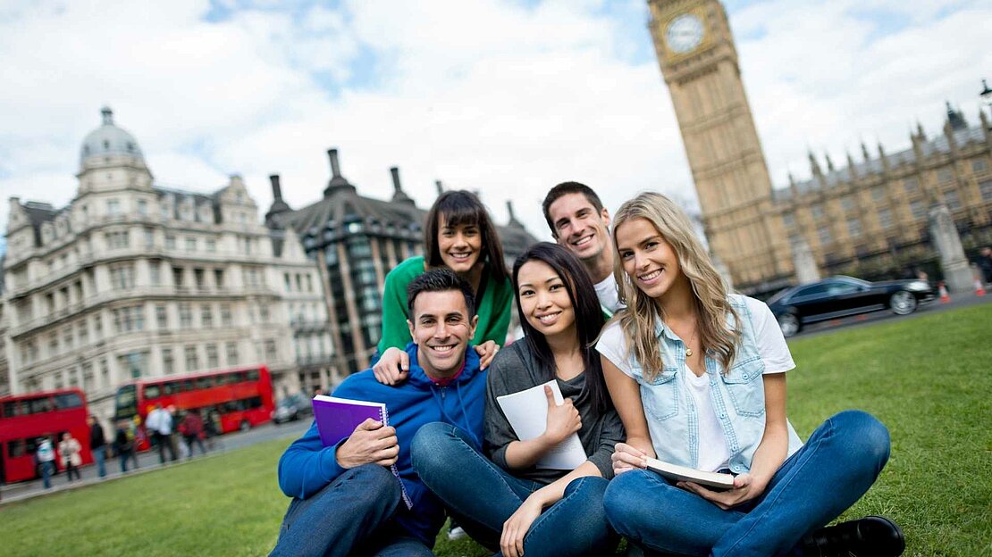 Foto: fünf junge Menschen die in die Kamera schauen. Hinter ihnen ist London abgebildet - Studium im Ausland 